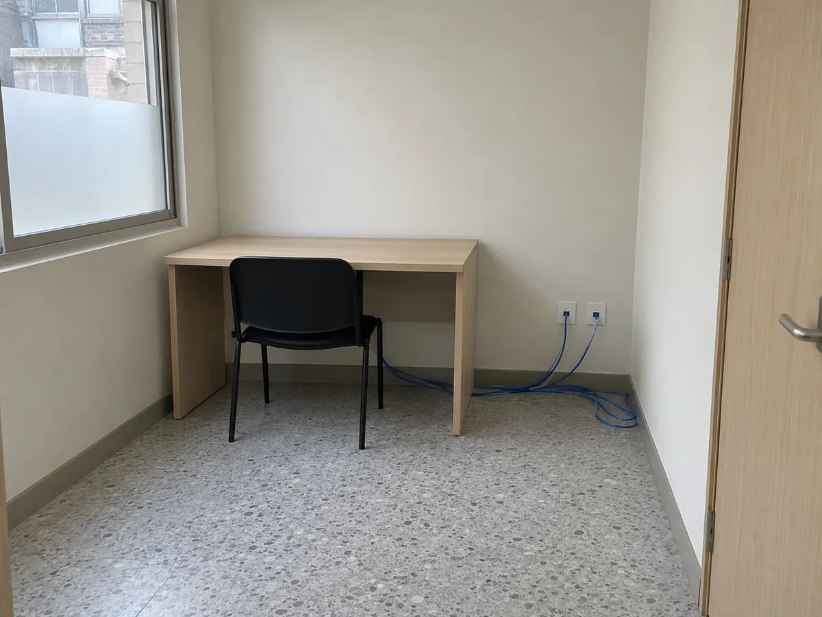 부산 통신 작업 장면 — 목재 책상 오른쪽 바닥에 늘어진 랜선