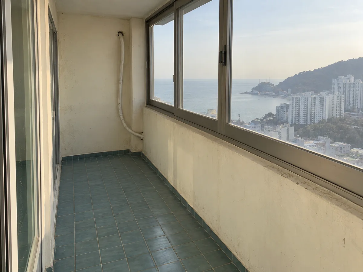 부산 에어컨·환기 작업 장면 — 바다가 보이는 베란다의 늘어진 보온 배관