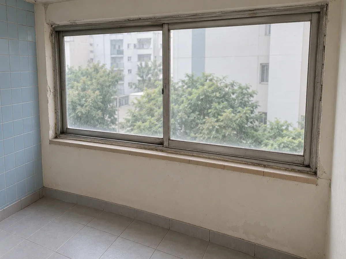 부산 샷시 작업 장면 — 낡은 은색 창틀과 갈라진 둘레 마감